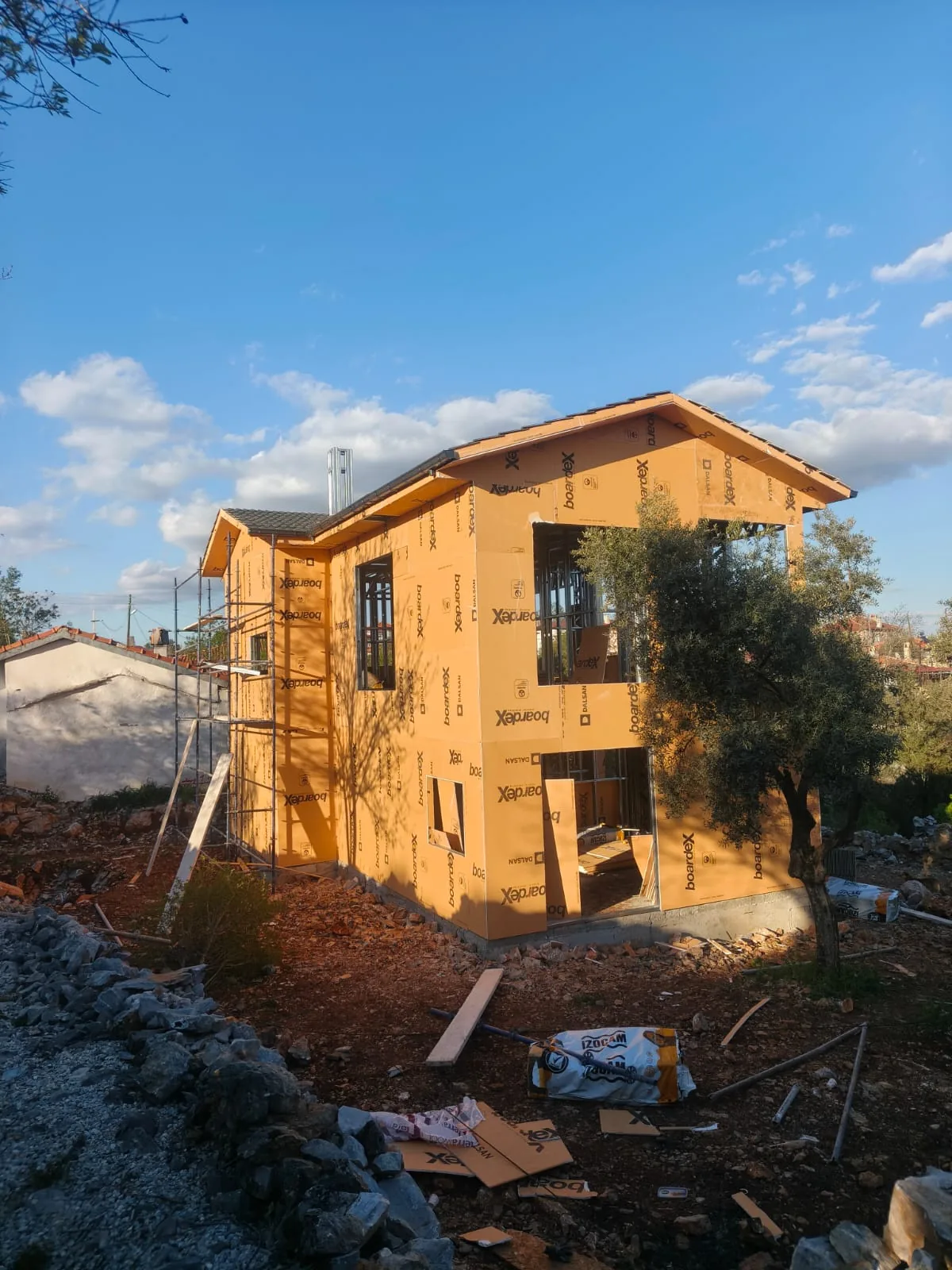 Dış kaplama ve pencere açıklıkları olan iki katlı yapı